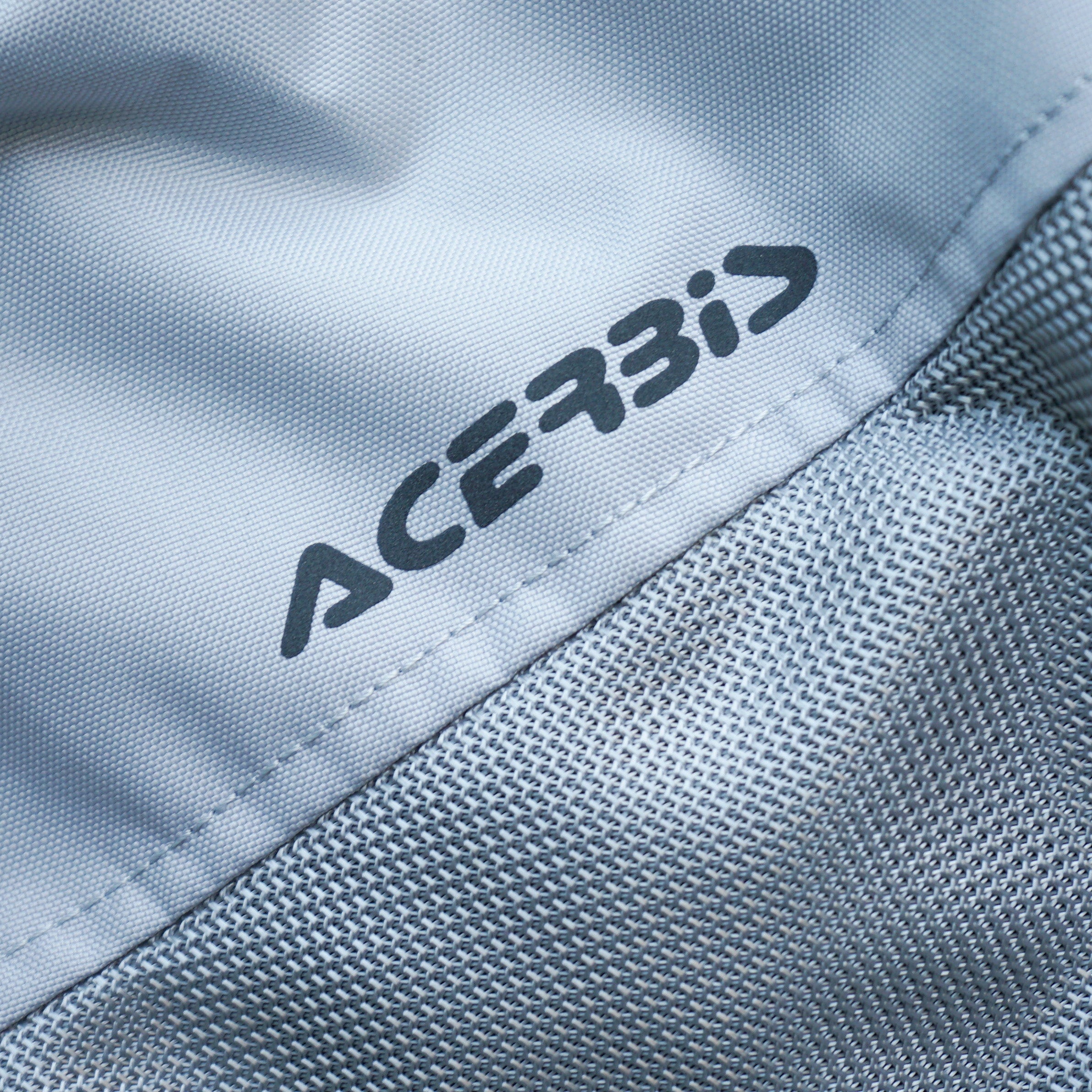 Close-up of a gray jacket with 'Acerbis' branding