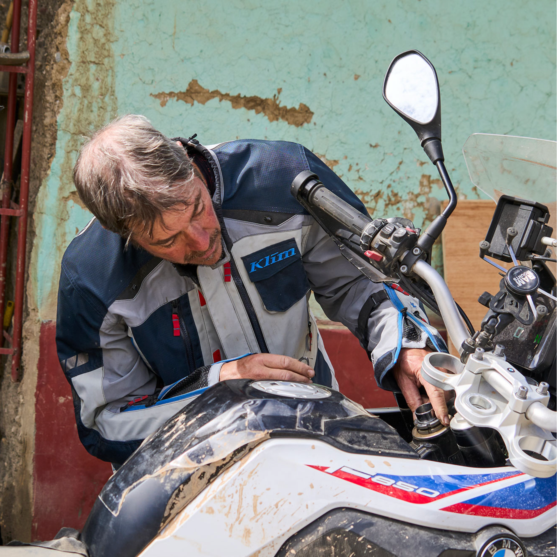 Two men working on a motorcycle in an outdoor setting.