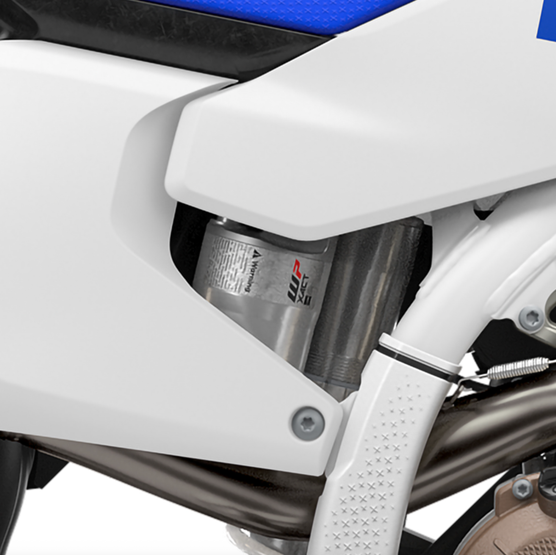 Close-up of a motorcycle's suspension system with a white and blue color scheme.