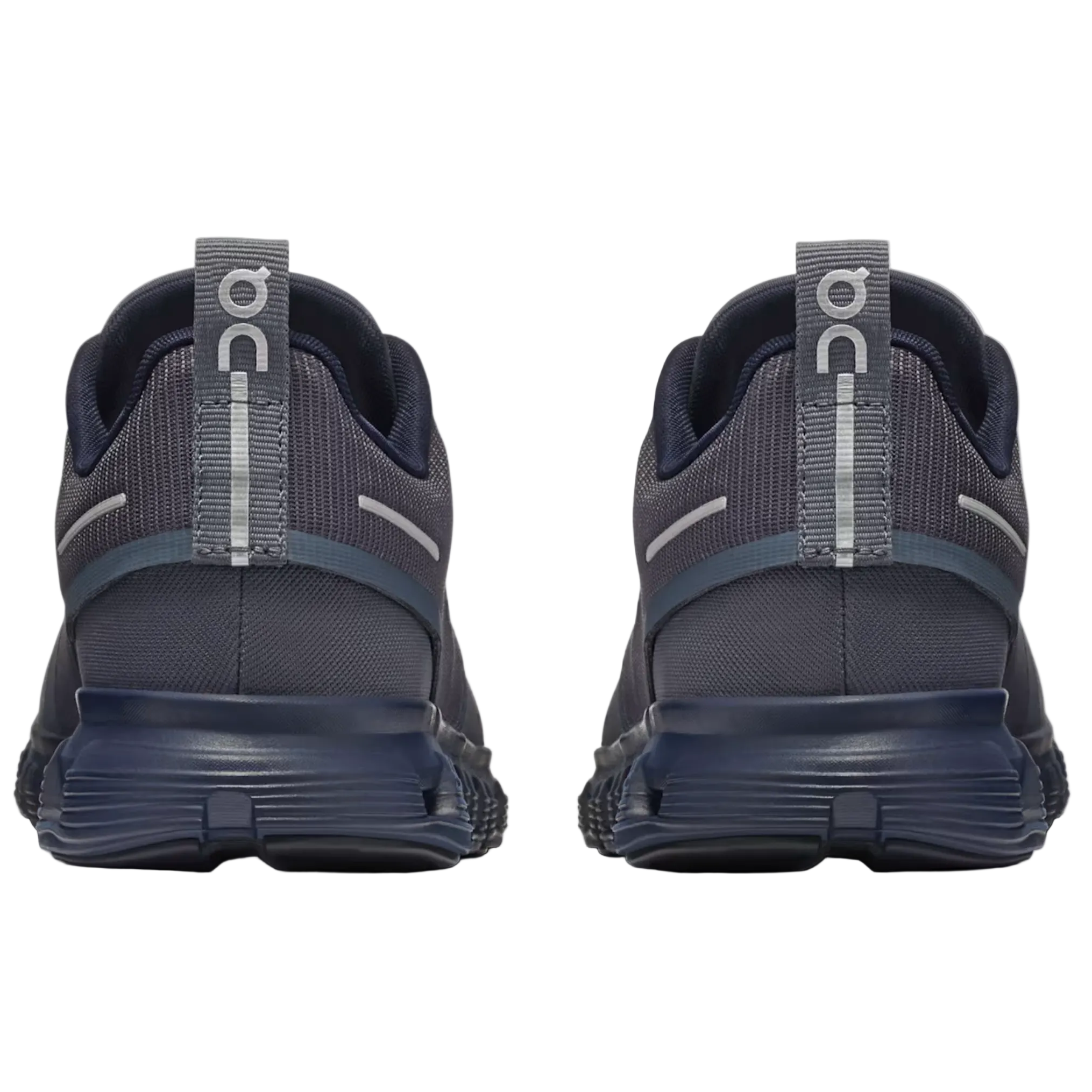 A pair of dark gray and navy blue running shoes shown from the back, featuring a textured mesh upper, a thick navy sole, and a gray pull tab with the 'on' logo.
