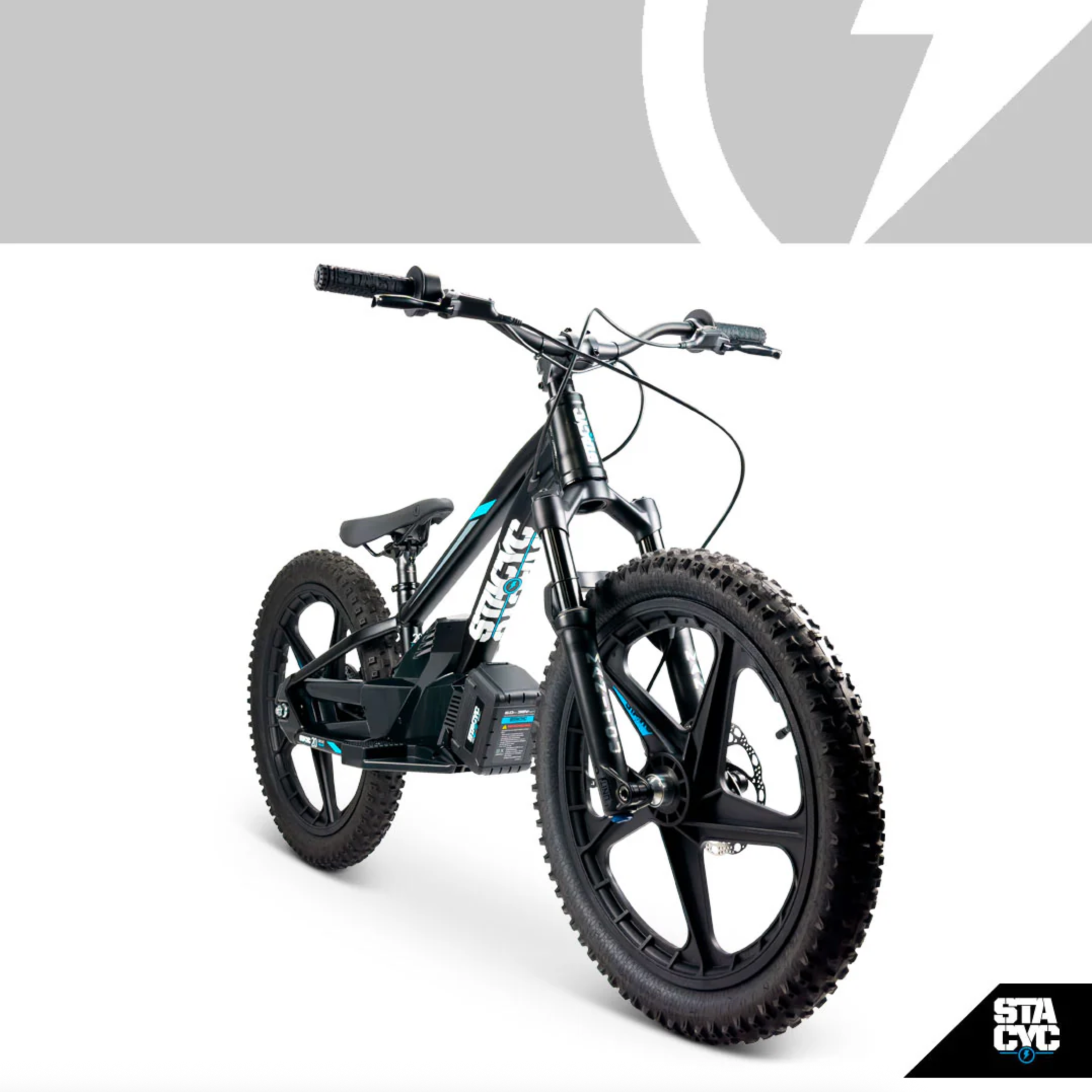 A black electric mountain bike with fat tires and a visible battery pack, photographed on a clean white studio background with a gray graphic banner at the top and an STACYC logo in the bottom right corner.