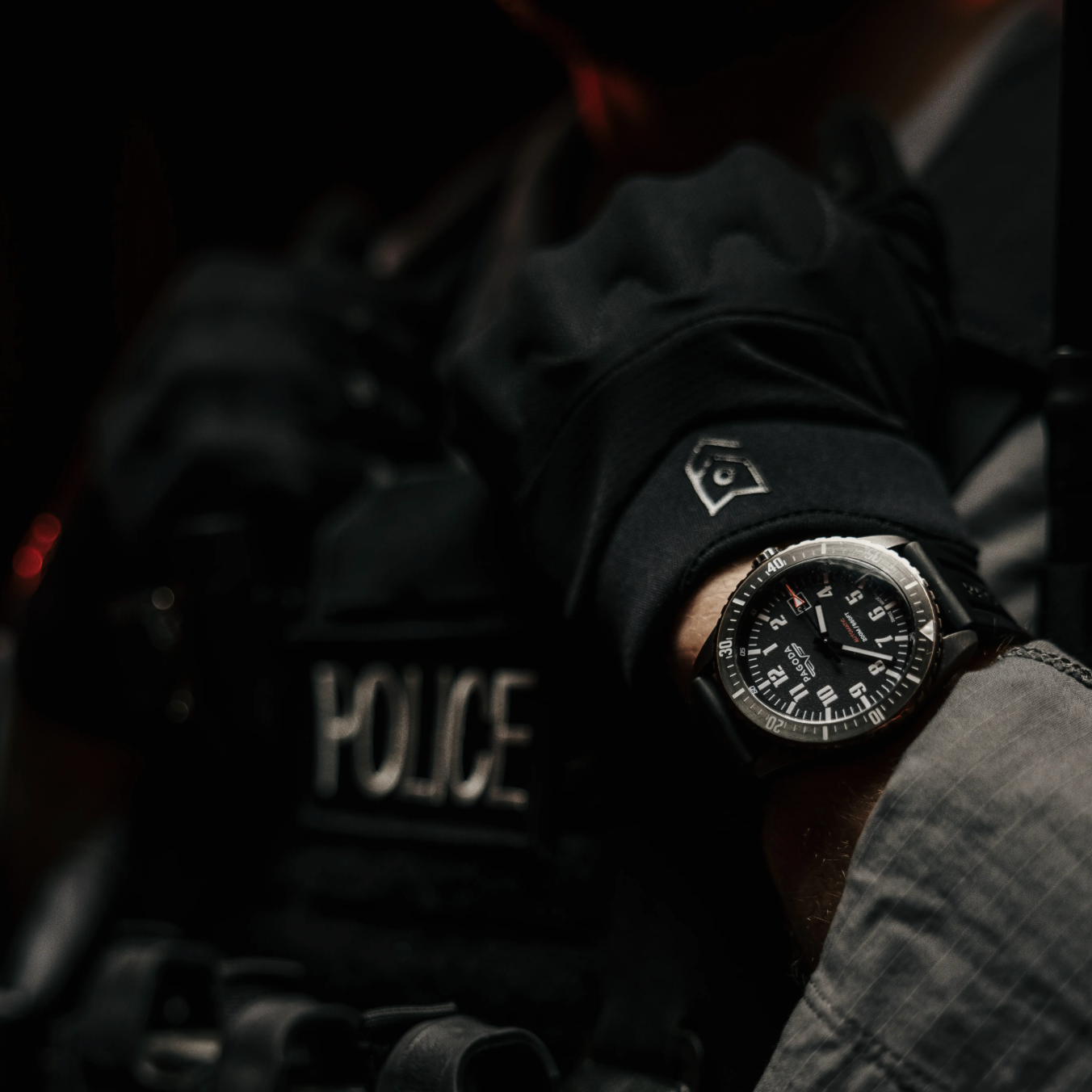 Person wearing a police uniform with a watch on their wrist.